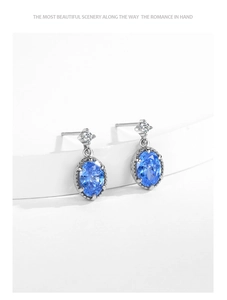 Détail macro de boucles d'oreilles en argent S925 avec zircon bleu et bords perlés