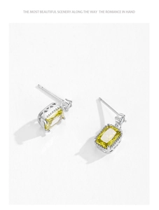 Macro view of S925 silver stud earrings with yellow square zircon and hollow pattern