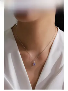 Close-up of elegant lavender pear-cut crystal pendant necklace on model with white shirt