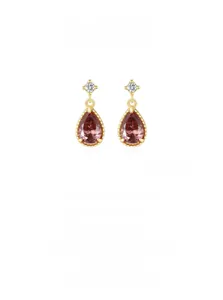 Gros plan sur boucle d'oreille goutte dorée 14K avec zircon rose et serti à griffes