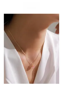Gros plan d'un collier en argent S925 avec pendentif carré rose porté par un mannequin