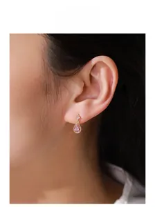 Gros plan de boucles d'oreilles goutte en zircon rose plaqué or 14K sur modèle