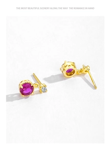 Macro view of gold S925 silver stud earrings with red zircon and floral crown settings