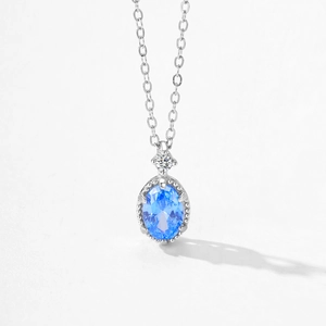 Élégant collier en argent 925 avec pendentif en zircon bleu ovale sur fond blanc pur