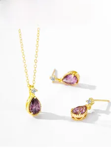Détail d'un ensemble de bijoux en argent 925 doré avec cristaux violets en goutte