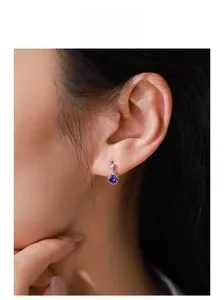 Close-up of S925 sterling silver stud earring with violet zircon stone on a model