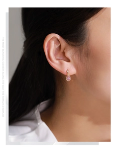 Détail d'une boucle d'oreille goutte d'eau en argent S925 et zircon rose sur modèle