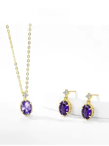 Détail de la parure de bijoux améthyste avec pierres ovales et collier doré sur socles