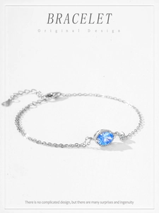 Macro view of S925 silver bracelet featuring oval blue zircon and lobster clasp