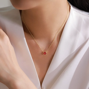 Elegant gold S925 silver necklace with round red ruby pendant on white silk fabric