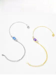 Detailed view of silver and gold bracelets with purple crystals and S925 engraved charms