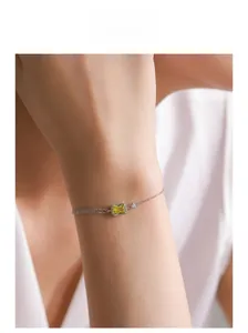 Model wearing a double-strand silver bracelet with rectangular yellow zircon gemstone