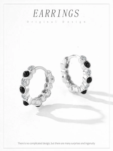 Close-up of S925 sterling silver hoop earrings featuring black and white zircon stones