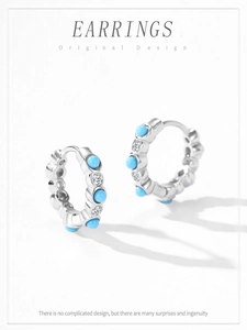 Détail macro de boucles d'oreilles en argent avec oxydes de zirconium et turquoise