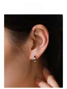 Close-up of S925 silver hoop earring with black and white zircon stones on model