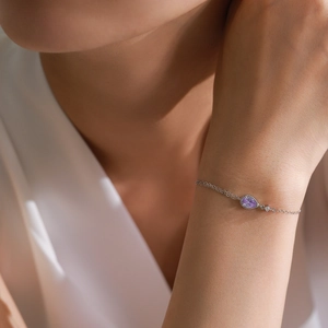 Elegant S925 sterling silver bracelet with a pear-cut purple zircon on model's wrist