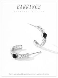 Détail de boucles d'oreilles en argent S925 en forme de S avec zircons noirs vintage