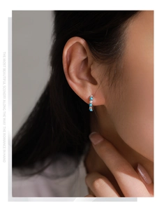 Close-up of S925 silver hoop earrings with blue turquoise and cubic zirconia stones