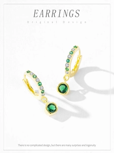 Detail of emerald green gemstone earrings with gold plating and cubic zirconia accents