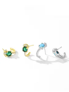 Detail of J-shaped S925 silver earrings with turquoise and emerald stones plus zircon