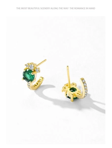 Detail of J-shaped S925 silver earrings with green stones and zircon accents