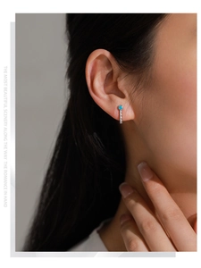 Close-up of S925 silver vintage gold earring with green zircon on model ear