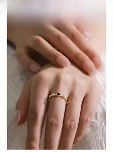 Detail of a gold bamboo-style S925 silver ring featuring a round blue lapis stone