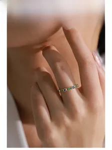 Macro view of gold silver ring featuring multi-colored zircons worn on female hand