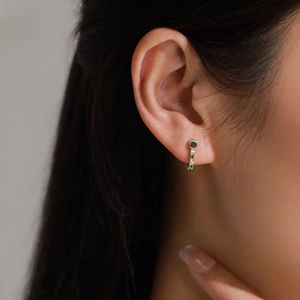Boucles d'oreilles vintage dorées en J avec émeraude et zircons portées par mannequin