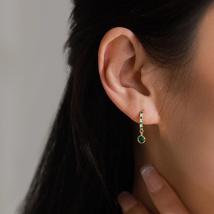 925 silver gold huggie earrings with green zircon pendants shown on model ear