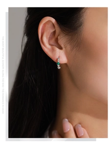 Gros plan sur boucle d'oreille créole en argent style bambou avec malachite verte