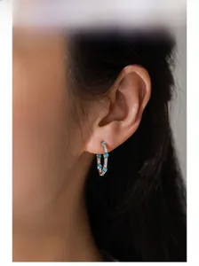 Detailed close-up of 925 sterling silver hoop earrings featuring turquoise stones on model