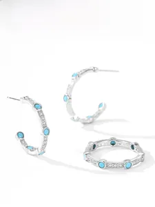 Detail of 925 sterling silver hoop earrings and ring set with turquoise stones