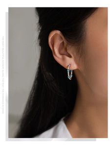 Close-up of model wearing 925 sterling silver hoop earrings with turquoise and zircons