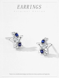 Detail of 925 silver star earrings featuring blue sapphires and sparkling white zirconias