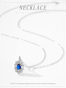 Close-up of a 925 silver snowflake necklace with a sapphire center and diamond accents
