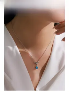 Close-up of 925 silver necklace with blue zircon star pendant on a model neck