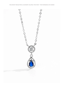 Detail of 925 sterling silver necklace with teardrop blue sapphire pendant and round stone