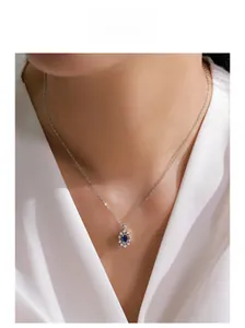 Detailed view of an S925 silver sunflower pendant with oval blue sapphire on a model