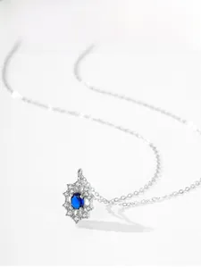 Detailed macro view of S925 sterling silver sunflower pendant with blue sapphire gemstone