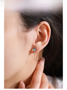 Detailed close-up of S925 sterling silver moonstone tassel stud earring on a model