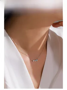 Fine chaîne en argent sterling avec trois pierres de lune rondes sur le cou d'un mannequin