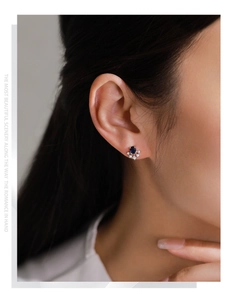Close-up of S925 silver sunflower stud earring with blue sapphire and white diamonds