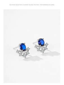 Macro detail of silver sunflower earrings with deep blue sapphire and sparkling zircons