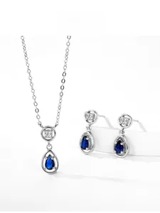 Macro shot of S925 sterling silver set with teardrop sapphire necklace and earrings