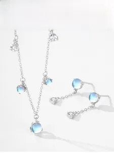 Detailed close-up of S925 sterling silver necklace and earrings set with moonstone