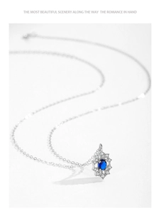 Detail of a snowflake pendant with oval blue sapphire and white cubic zirconia crystals