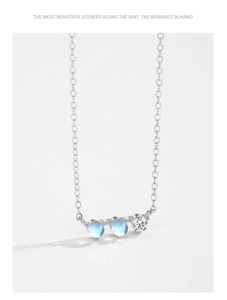 Gros plan détaillé du pendentif argenté avec pierres de lune bleues et cristaux de zircon