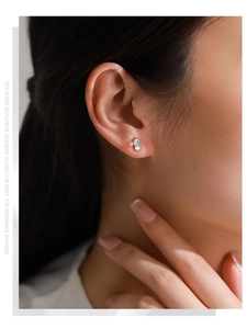 Gros plan d'une élégante boucle d'oreille en argent S925 avec pierre de lune sur modèle