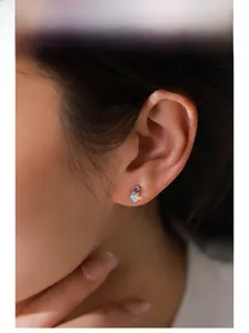 Gros plan d'une boucle d'oreille en argent S925 avec opale et zircon violet sur l'oreille